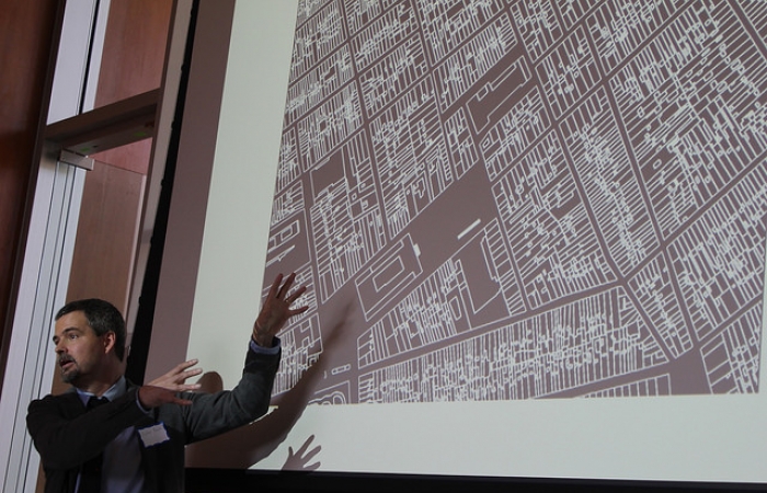 Zephyr Frank pointing to a projected map of Rio de Janeiro